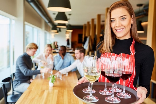 server with platter of wine glasses for customers